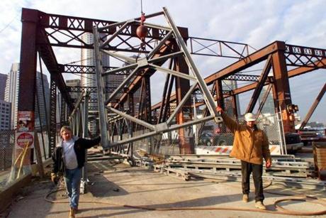 Boston- 1/27/99- Workers remove section of a steel pedestrian walkway that spanned The old Northern Avenue Bridge , after the Coast Guard ordered the pedestrian walkway removed . The bridge is expected to be open again in March to pedestrians.
